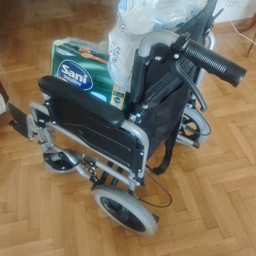 Folding wheelchair with handbrake and footbrake