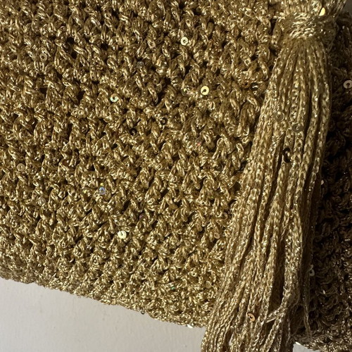 Handmade knitted shoulder bag in gold with decorative tassel