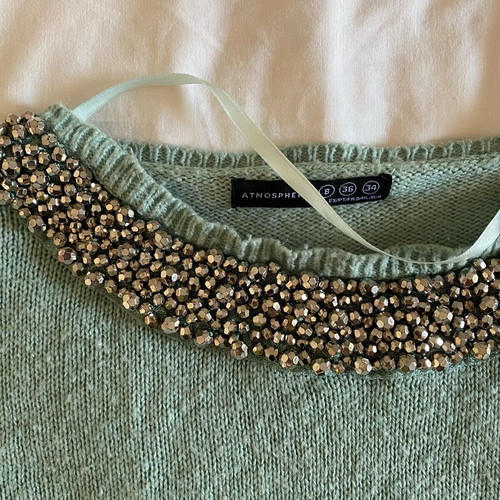 Thin turquoise sweater used with neckline details