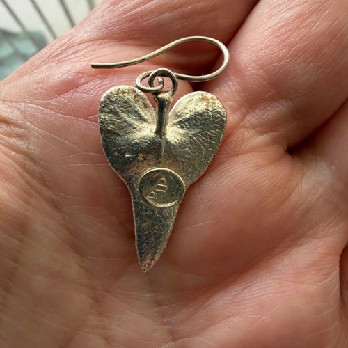 Heart-shaped dangling earrings used, silver color