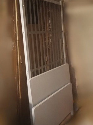 Blue iron single bed with mattress and wooden sofa with storage