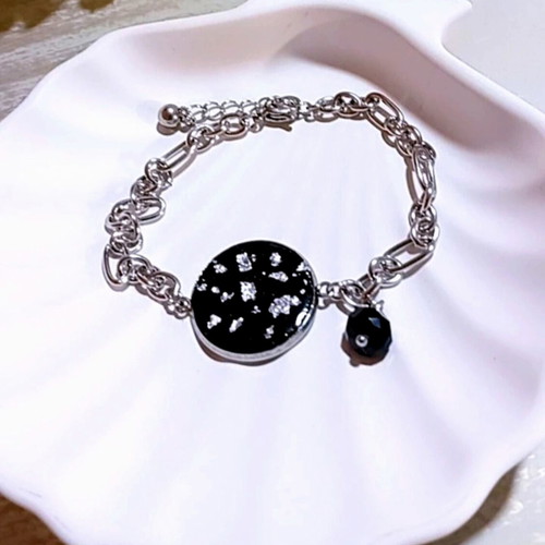 Handmade steel bracelet with iridescent black motif and silver flakes