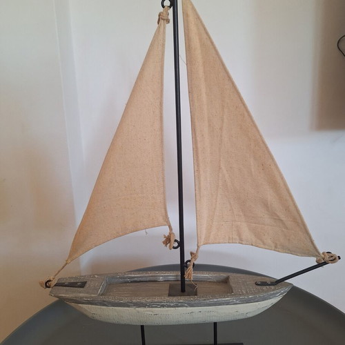 Decorative wooden sailboat with fabric sails and wooden lighthouse used