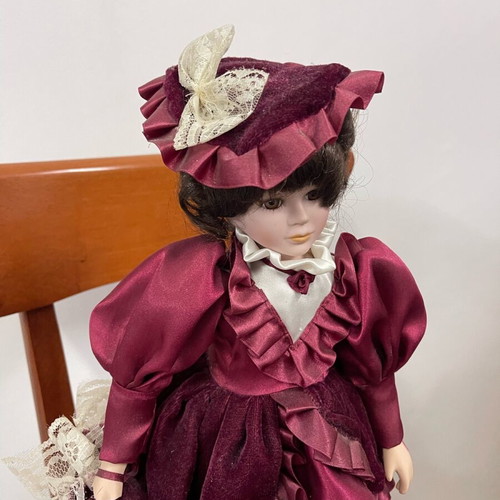 Porcelain doll used with satin and velvet dress, broken arm