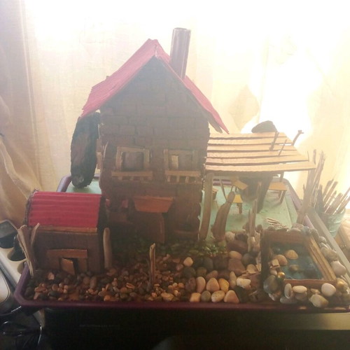 Handmade decorative house with cardboard, pebbles and driftwood, new