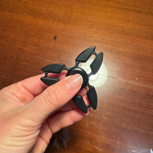 Metal fidget spinner used, black ninja star shuriken design
