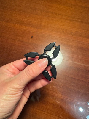 Metal fidget spinner used, black ninja star shuriken design