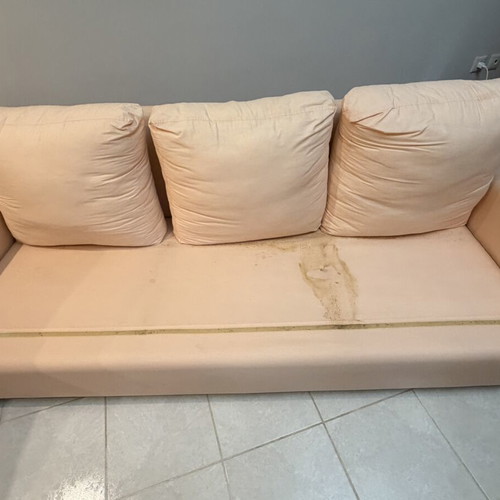 Three-seater fabric sofa used, light pink-peach color with side cushions