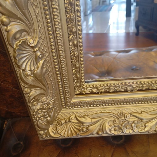 Baroque wall mirror with carved gold frame and embossed motifs