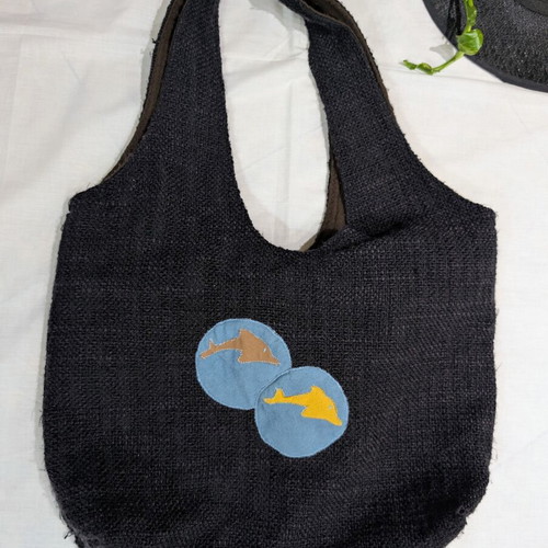 Large black fabric shoulder bag with dolphin decorations