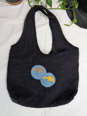 Large black fabric shoulder bag with dolphin decorations