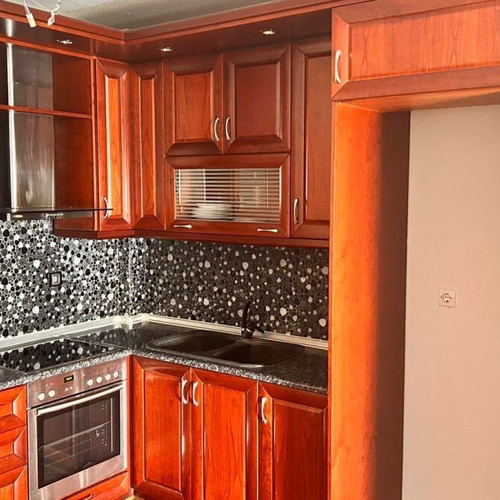 Corner kitchen made of solid cherry wood with extractor hood used