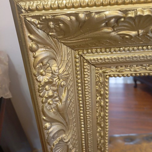 Baroque wall mirror with carved gold frame and embossed motifs