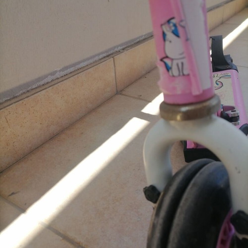 Pink children's scooter used with wear but fully functional