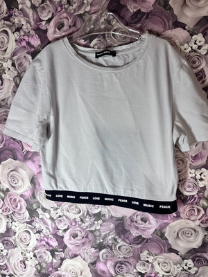 White short-sleeve crop top with black elastic band, size M