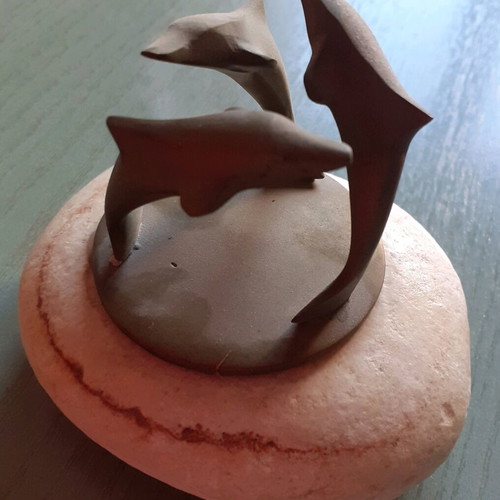 Decorative composition with three bronze dolphins used, on stone