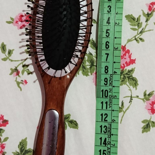 Small hairbrush with metal pins and rubber cushion