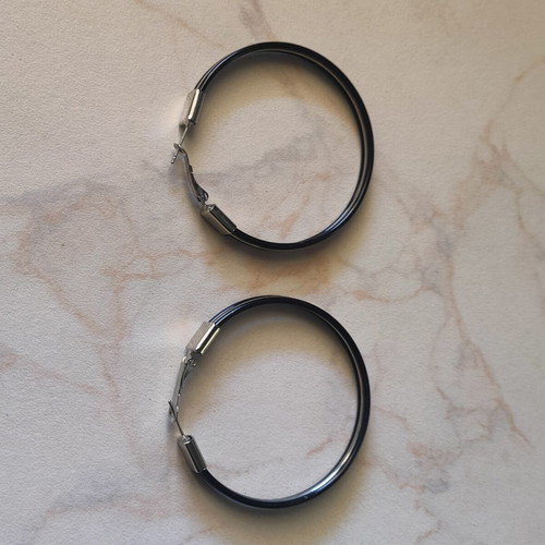 Large black hoop earrings used with silver details