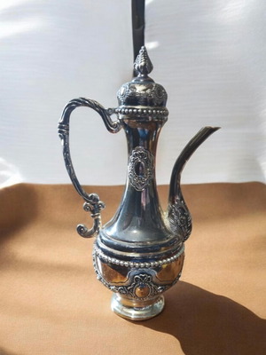Silver-plated antique pitcher with ornate embossed designs like new