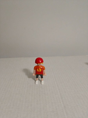 Playmobil figure with orange-red shirt and helmet used