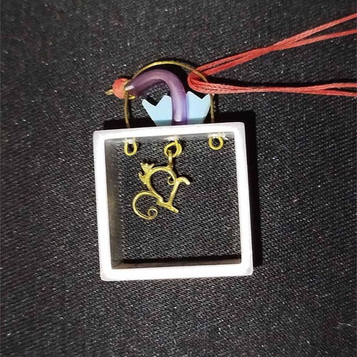 Sculpted pendant like new with square frame and red cord