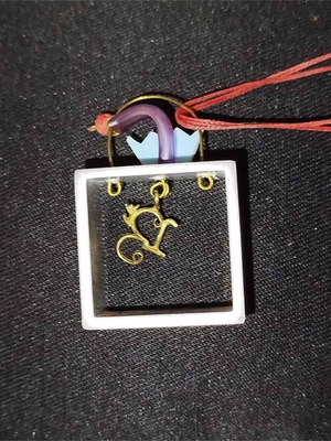 Sculpted pendant like new with square frame and red cord