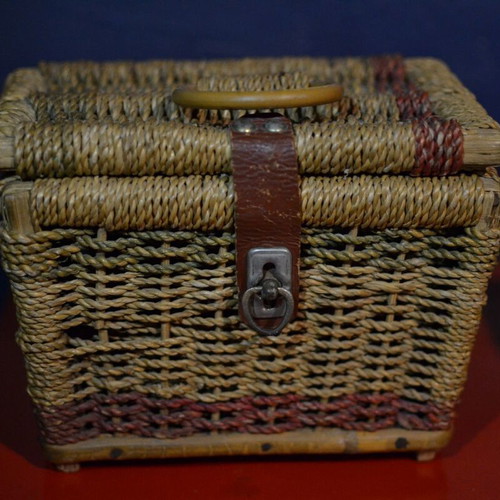 Vintage wicker storage basket used with leather strap and metal clasp