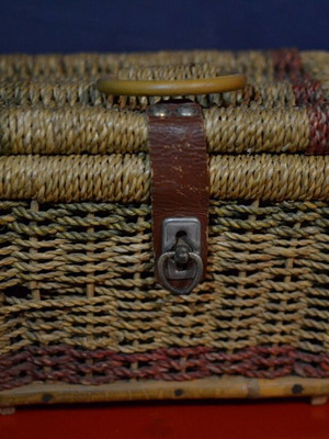 Vintage wicker storage basket used with leather strap and metal clasp