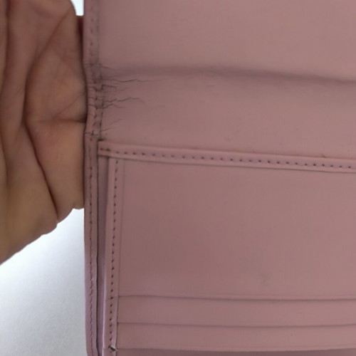 Dior wallet used, pink with slight wear and missing stud