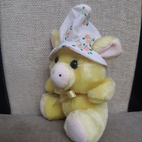 Yellow plush piglet with fabric hat and bow