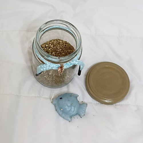 Decorative jar with candle fish and golden sand