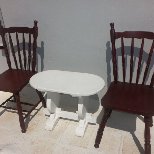 Wooden set with oval white table and 2 traditional dark chairs used for outdoor