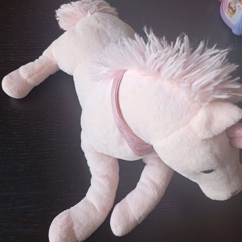 Pink plush unicorn toy used in lying position