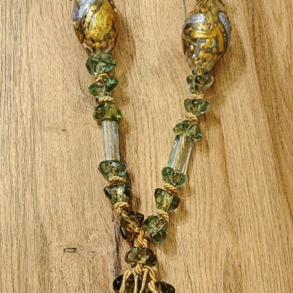 Tabletop komboloi with green and gold glass beads