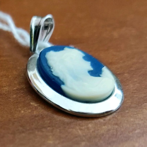 Cameo new with blue background and carved young woman figure