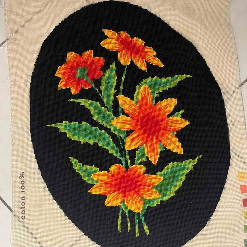 Handmade embroidery with orange daisies on black background used