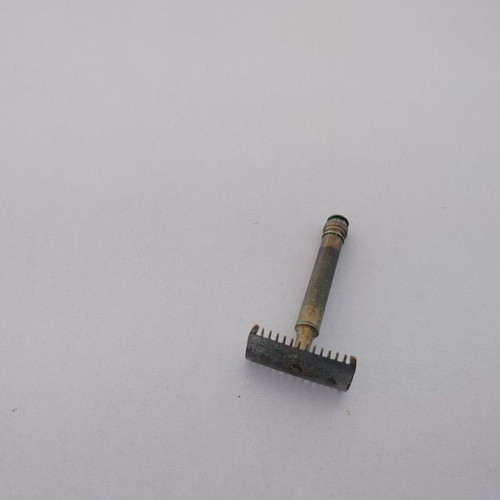 Vintage brass razor used with visible wear and oxidation