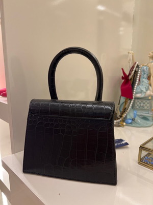 Small black handbag used with strap inside