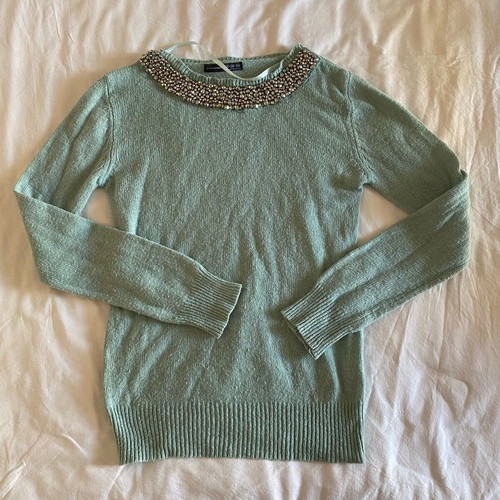 Thin turquoise sweater used with neckline details