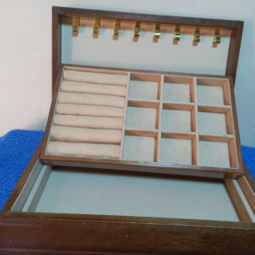 Wooden jewelry box used with velvet-lined compartments