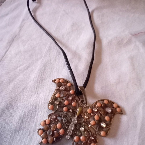 Metal butterfly pendant used on black cord