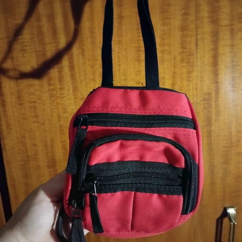 Small red shoulder bag used with multiple compartments