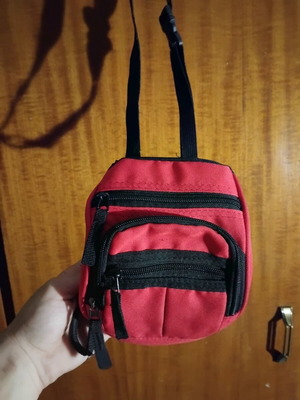 Small red shoulder bag used with multiple compartments