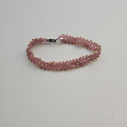 Handmade bracelet with pink beads and gold details used