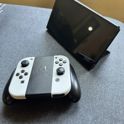 Nintendo Switch OLED console used with 3 games and Zelda cases