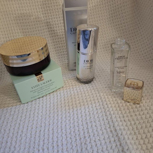 Empty Dior and Estèe Lauder cosmetic jars used, set