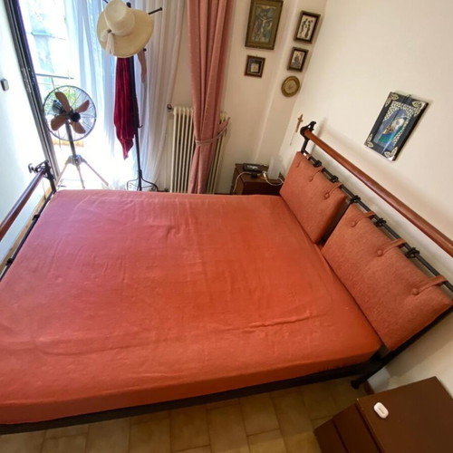Double bed with black metal frame and wooden headboard