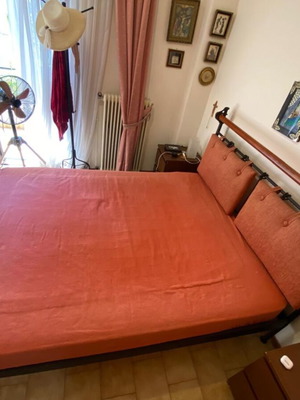 Double bed with black metal frame and wooden headboard