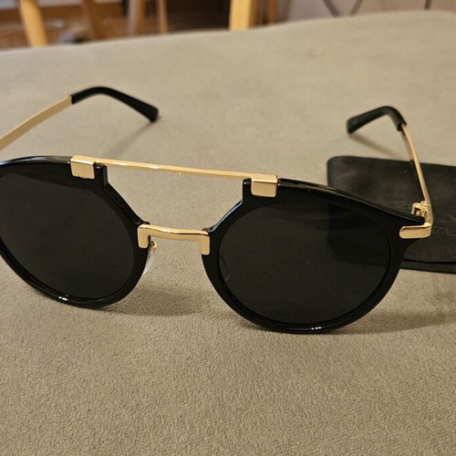 Modern sunglasses with gold frame and black round lenses