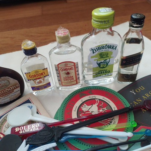 Vintage bar collection with mini liquor bottles, coasters, and stirrers